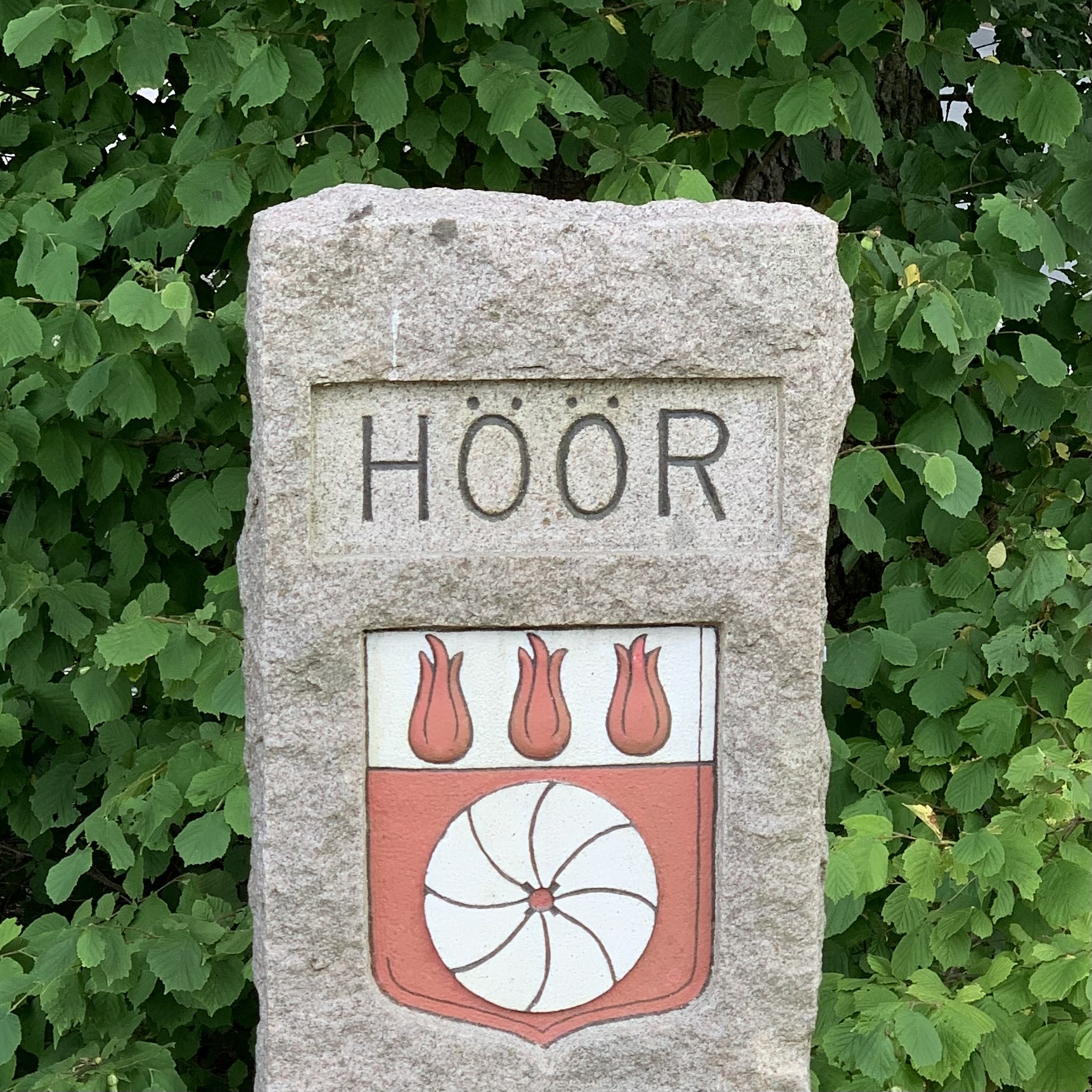 A large stone-rock with Höörs kommun logo on it.